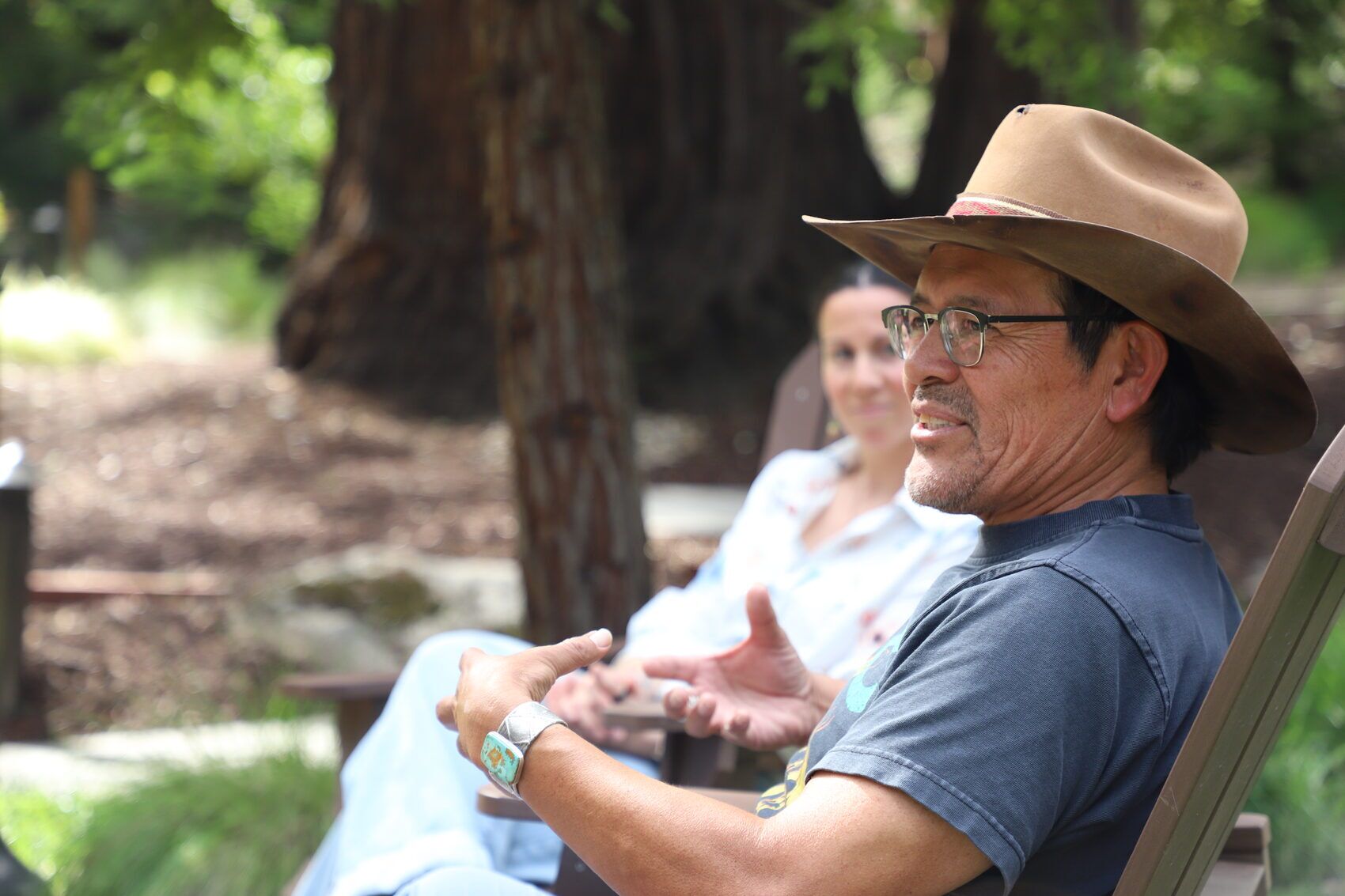 Tony in council with participants beneath the redwoods